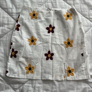 White with embroidered flower details. Size XS